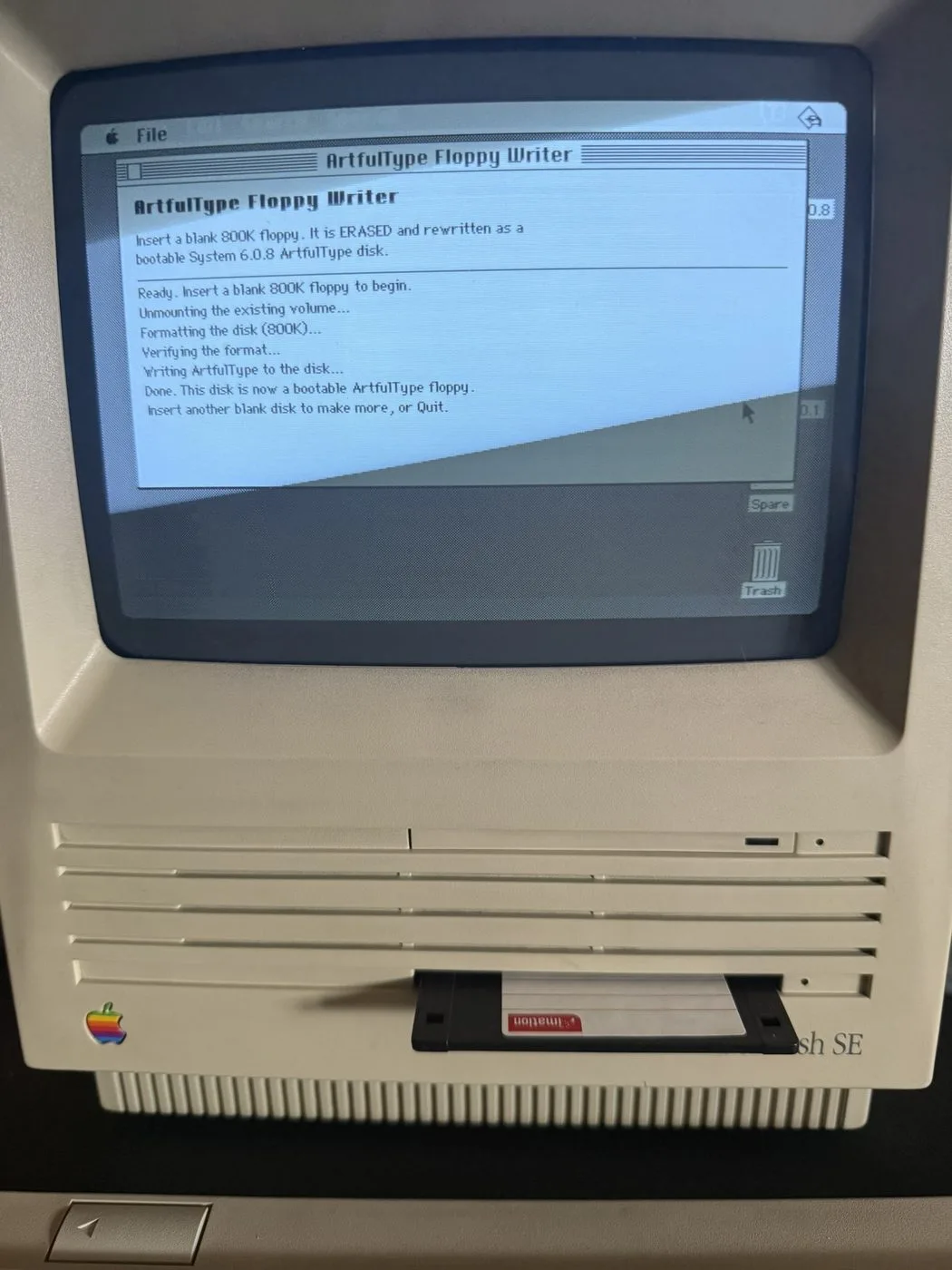 The ArtfulType Floppy Writer finishing a disk on a real Macintosh SE, with the floppy ejected