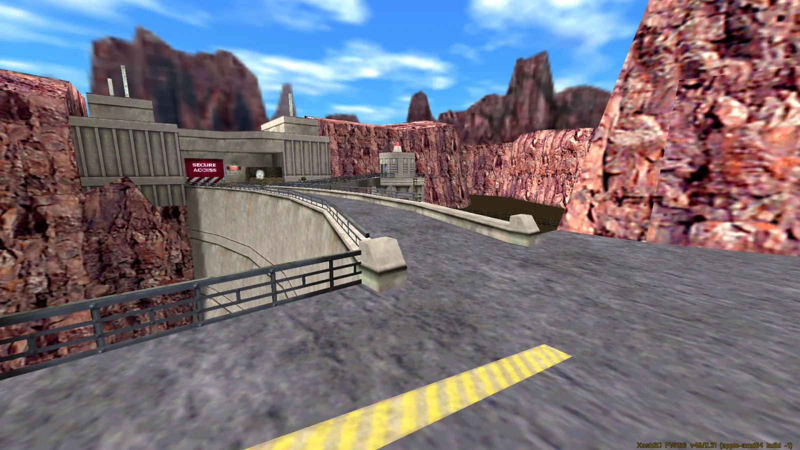 A concrete dam and roadway cut into red cliffs under a blue sky